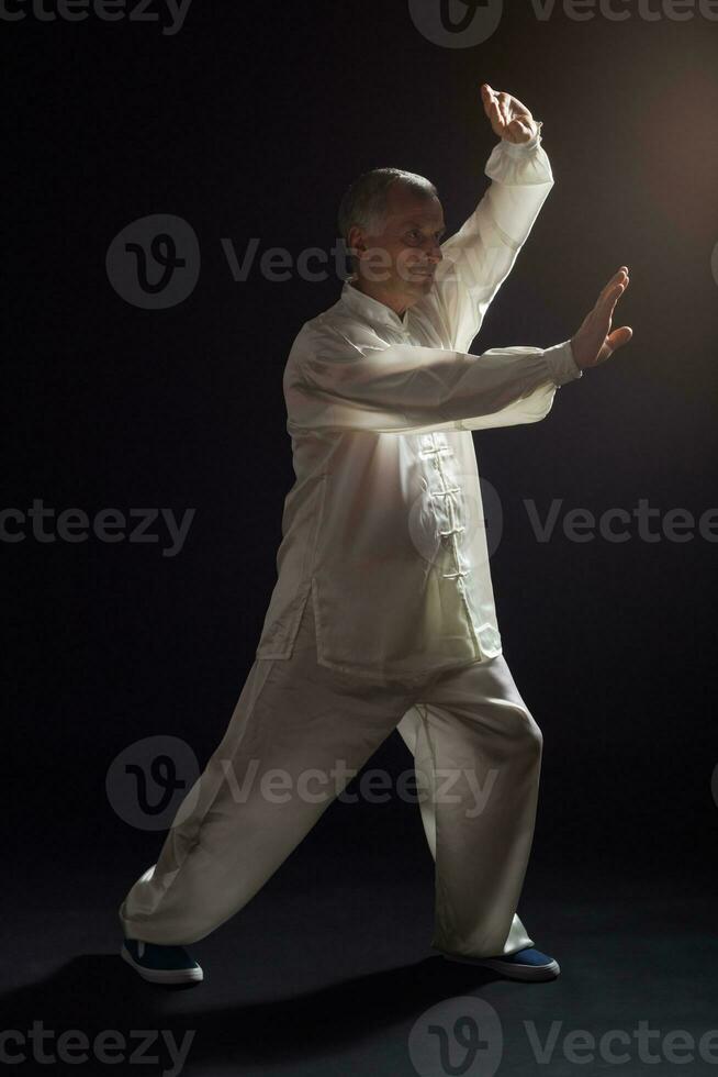 Senior man enjoys exercise Tai Chi indoor photo