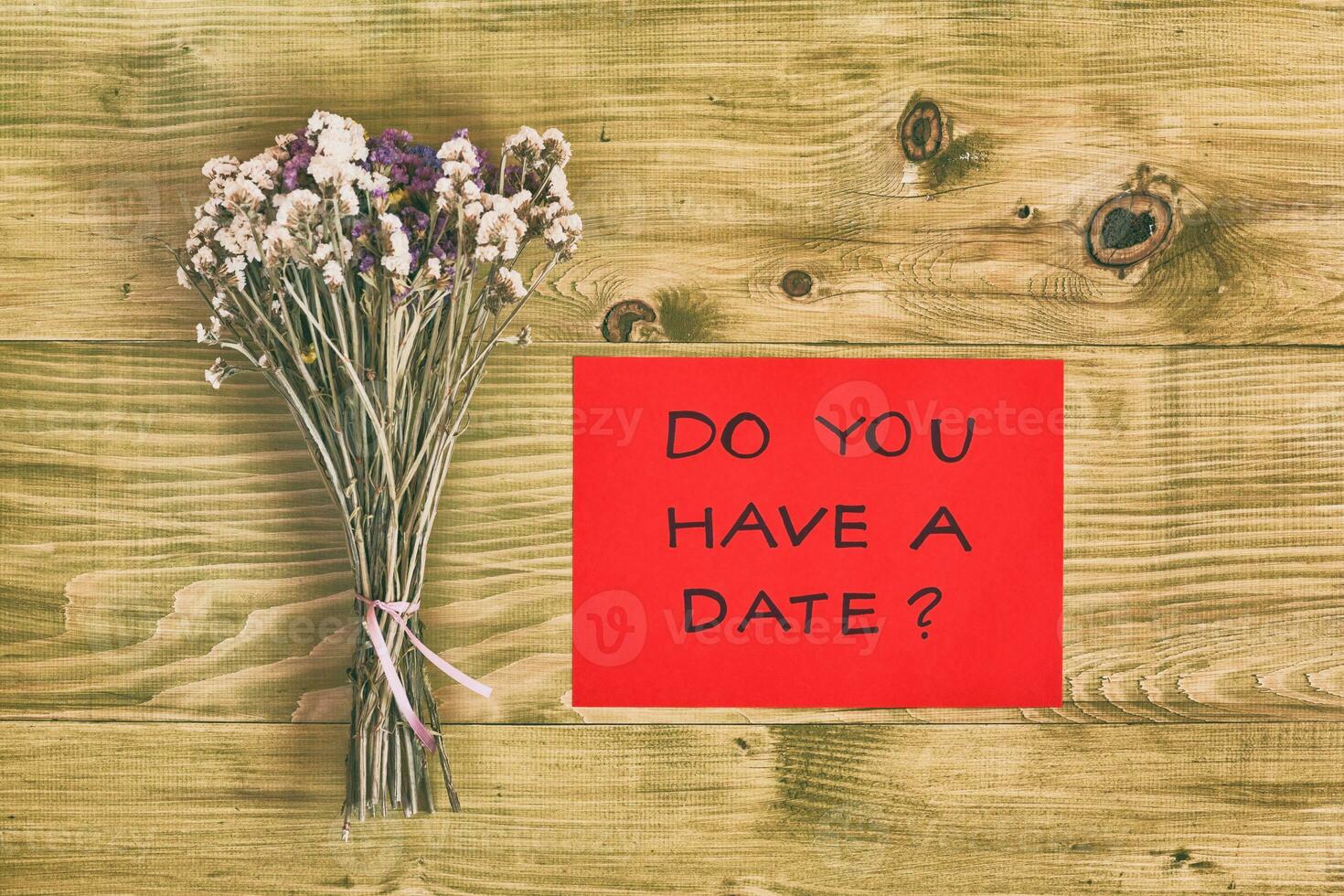 Bouquet of flowers with question do you have a date on wooden table photo