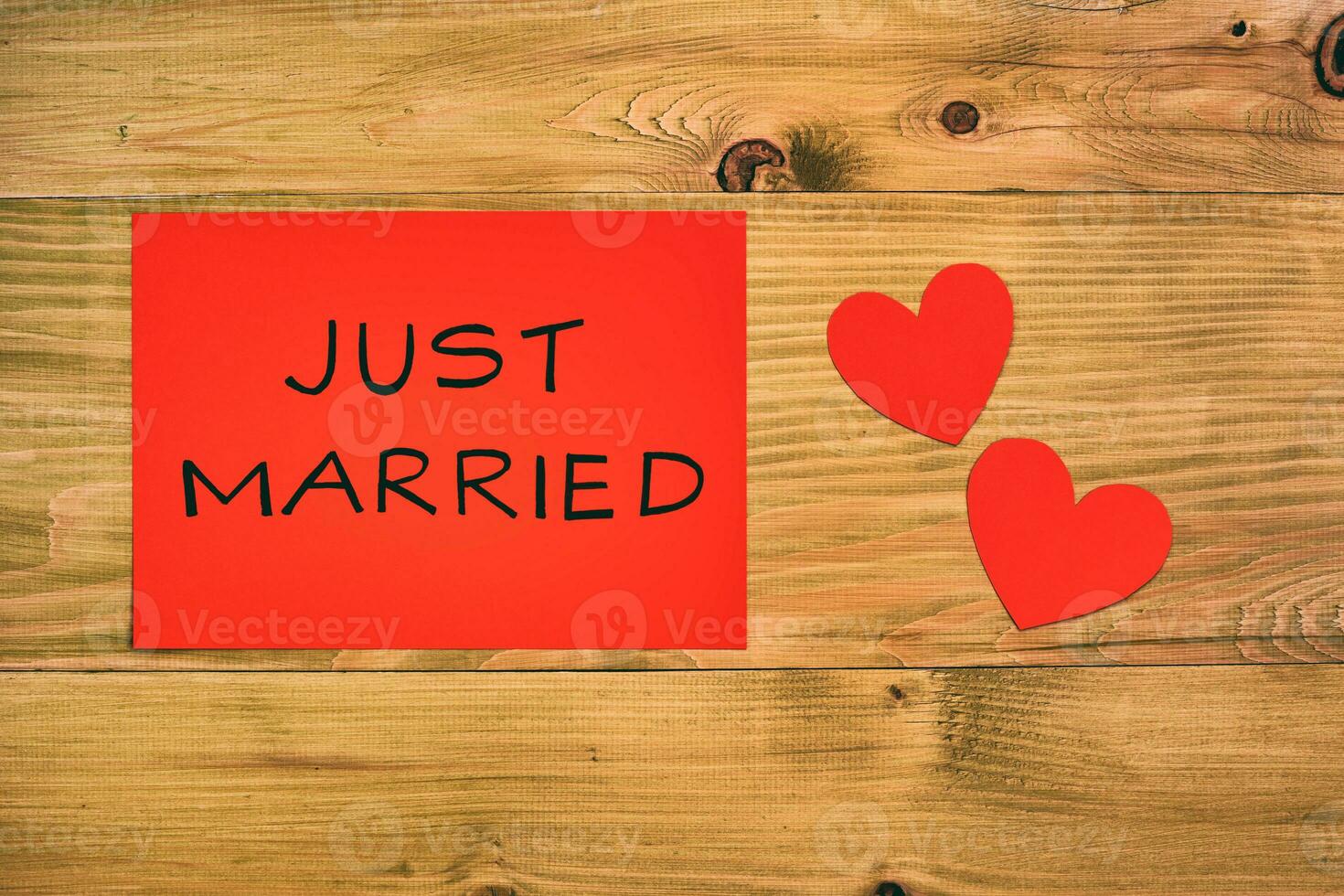 Text just married and heart shapes  on the red paper on wooden table photo