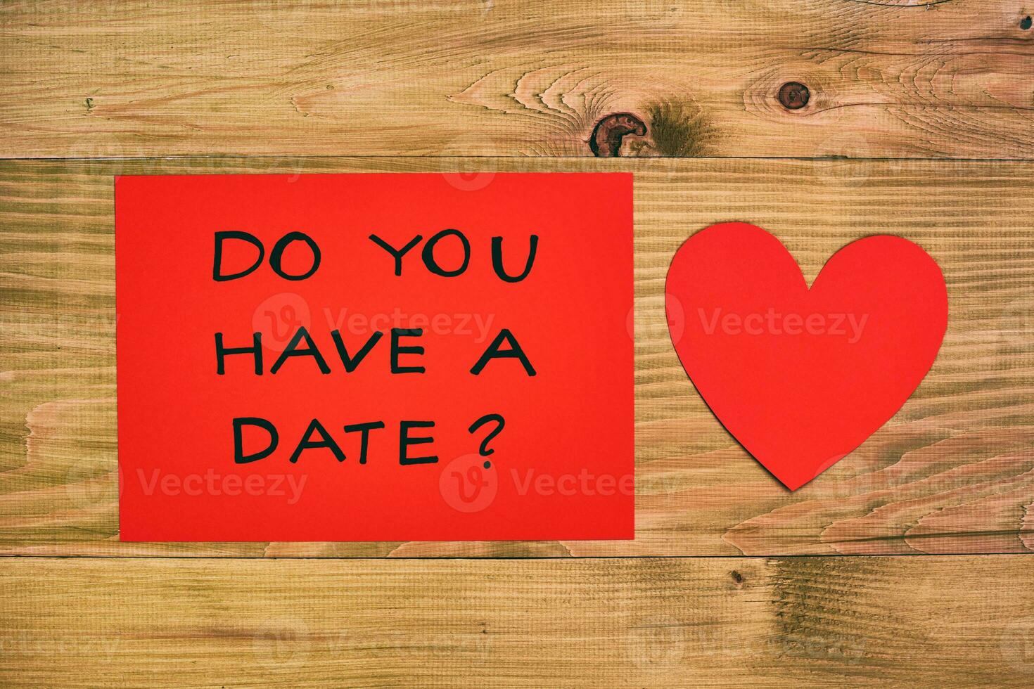 rojo papel con pregunta hacer usted tener un fecha y corazón en de madera mesa foto