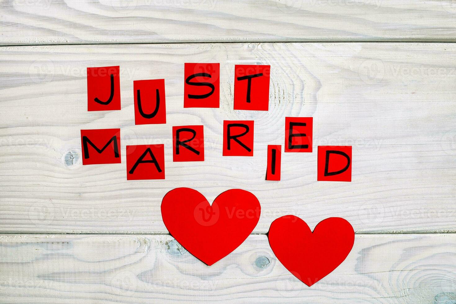 Text just married and heart shapes on wooden table photo