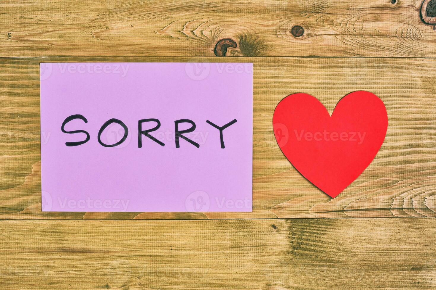 Sorry note on wooden table with heart photo