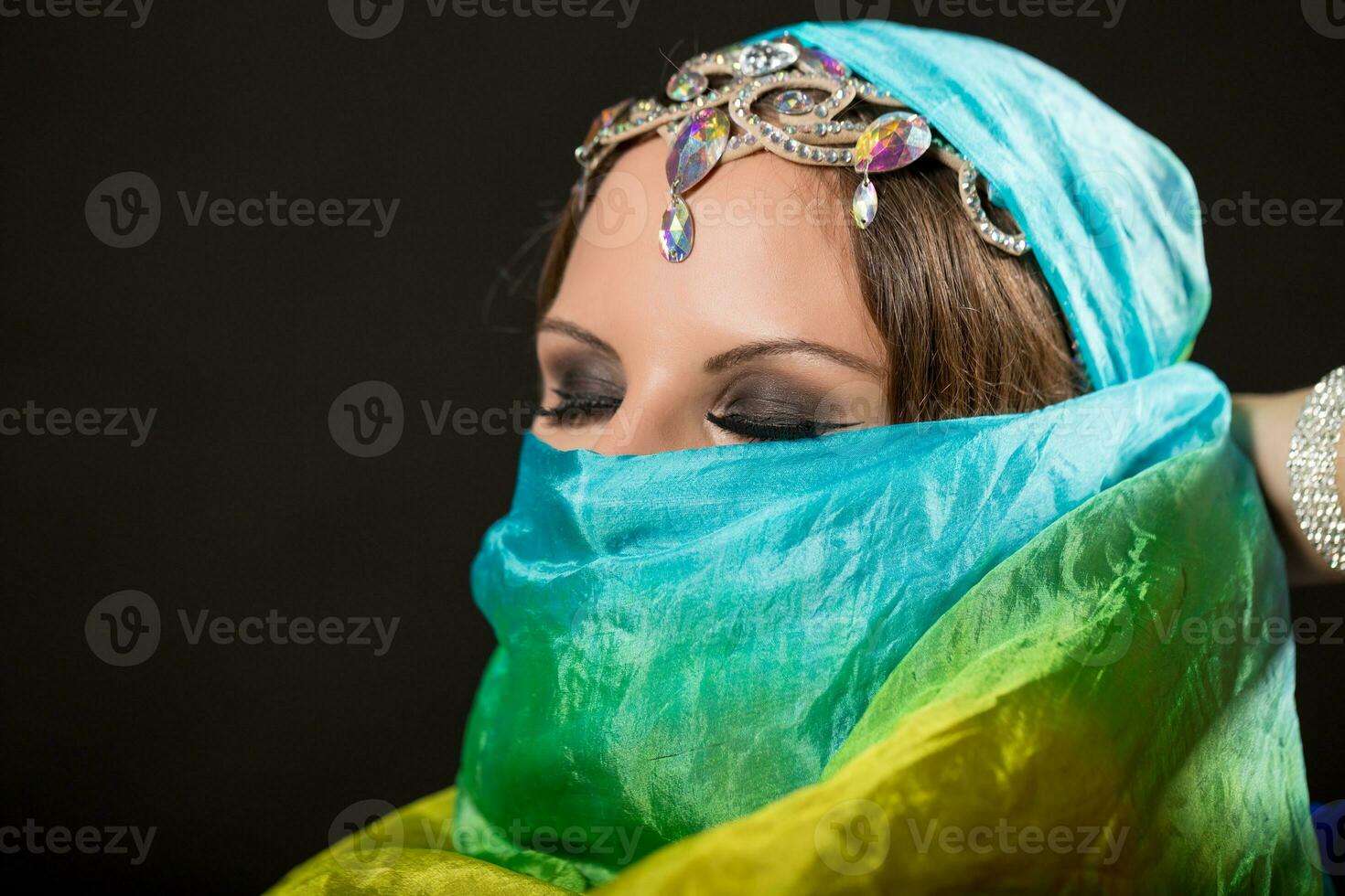 Close up portrait of belly dancer wrapped in veil photo