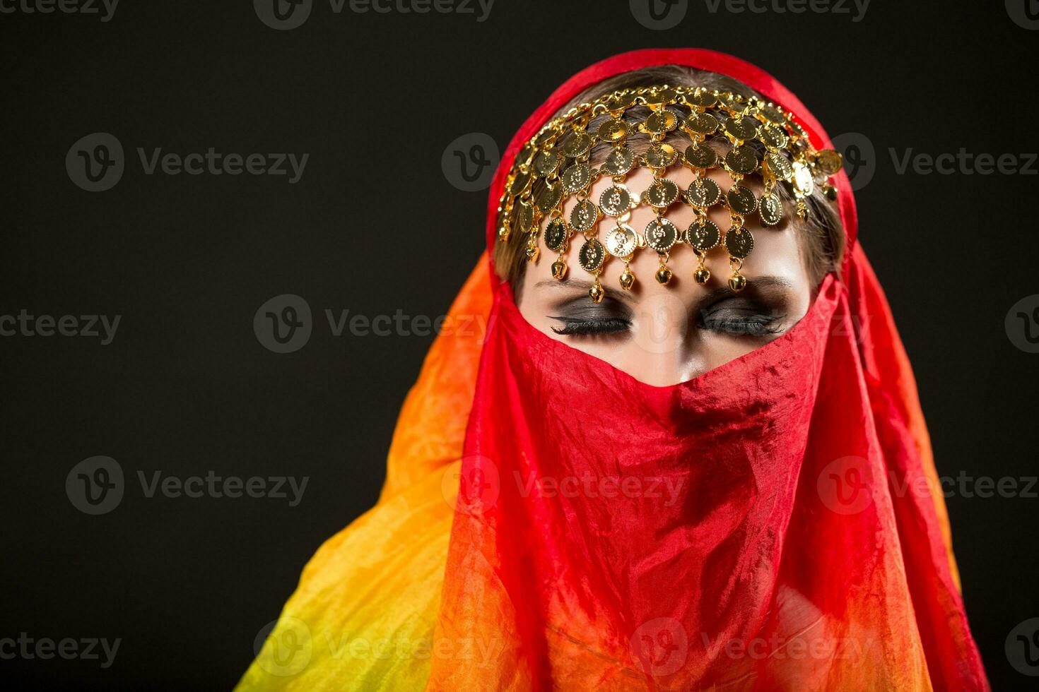 Close up portrait of belly dancer wrapped in veil. photo