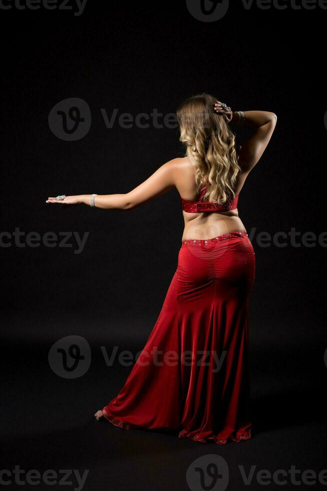 Belly dancer performing belly dance on black background photo