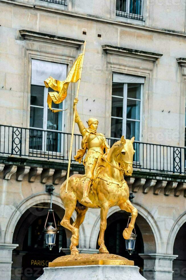 a statue of a woman on a horse with a flag photo