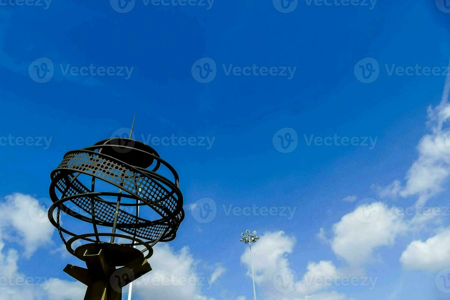 a metal globe with a blue sky in the background photo