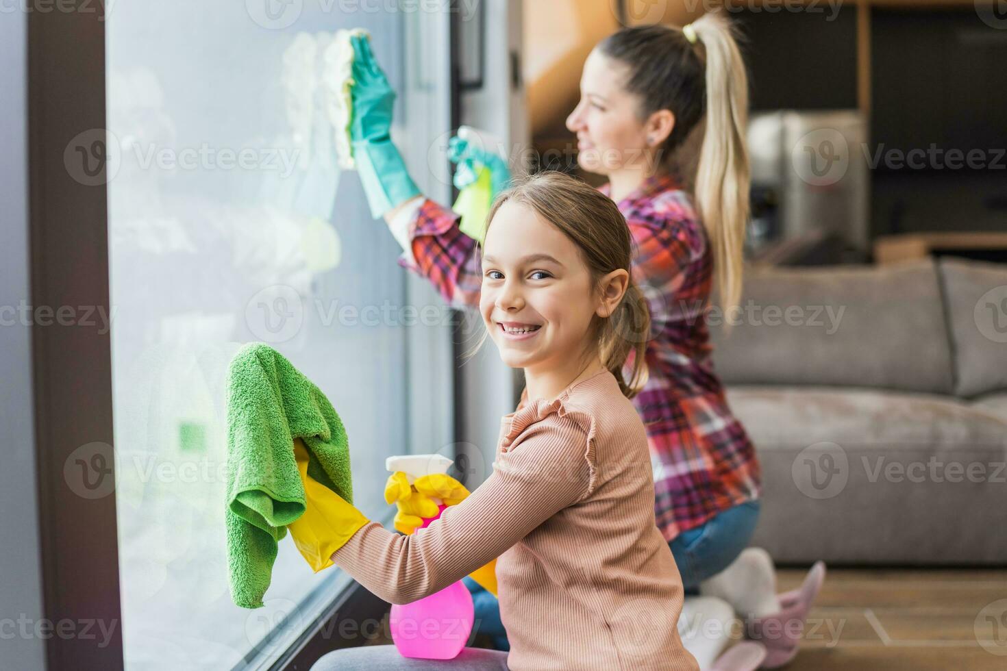 Happy daughter and mother cleaning house together photo