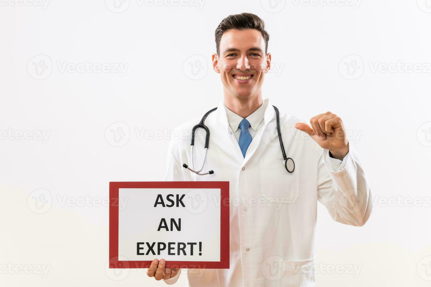 Image of doctor holding a paper with a text ask an expert and pointing at himself photo