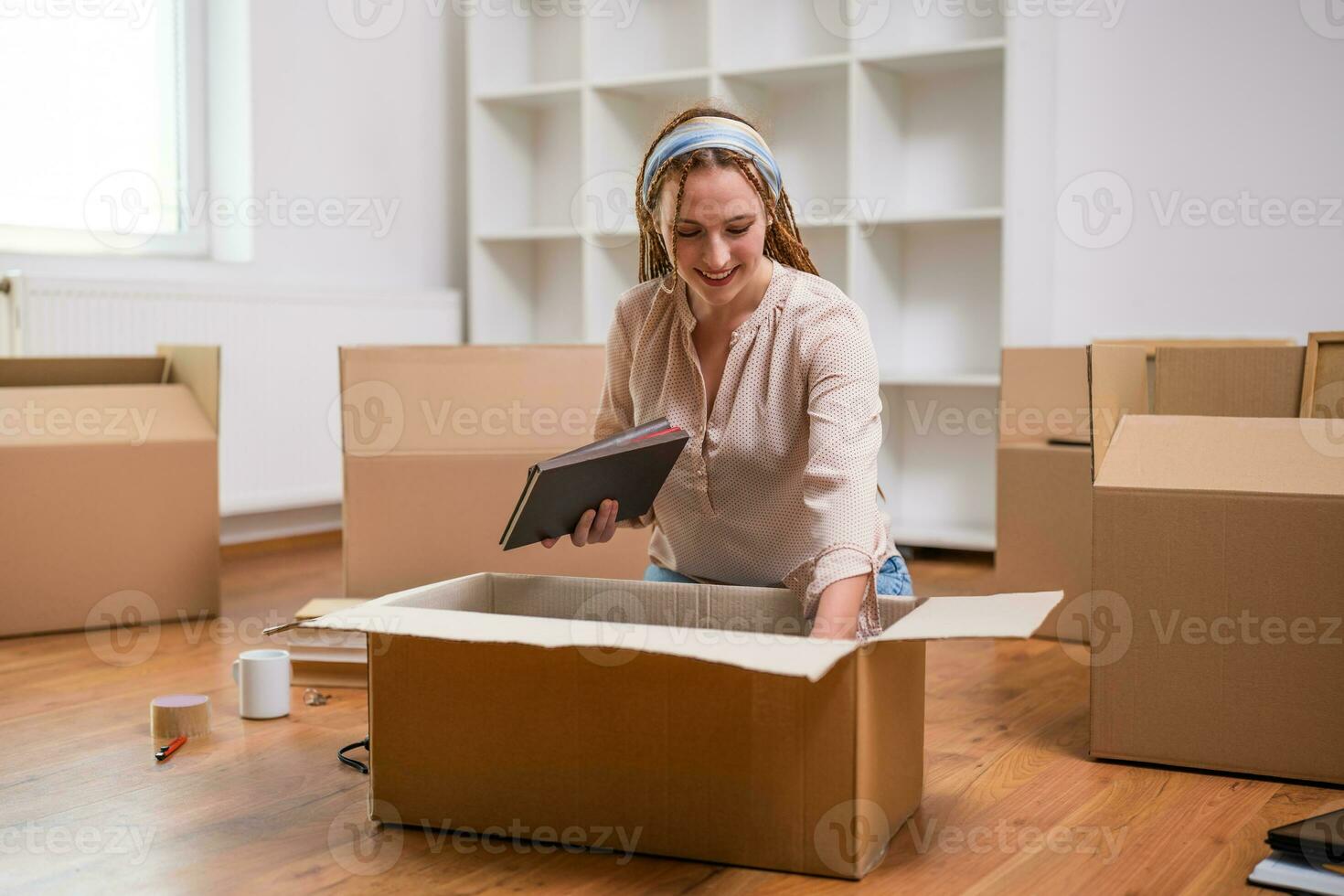 Modern ginger woman with braids moving into new home photo