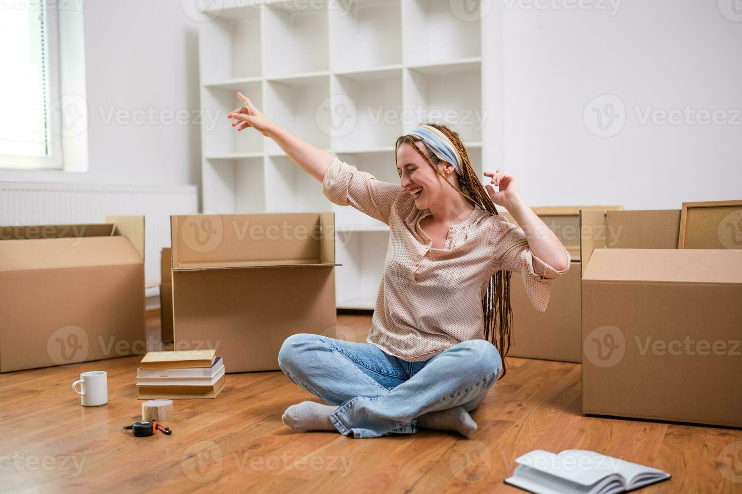 Excited ginger woman with braids moving into new apartment photo