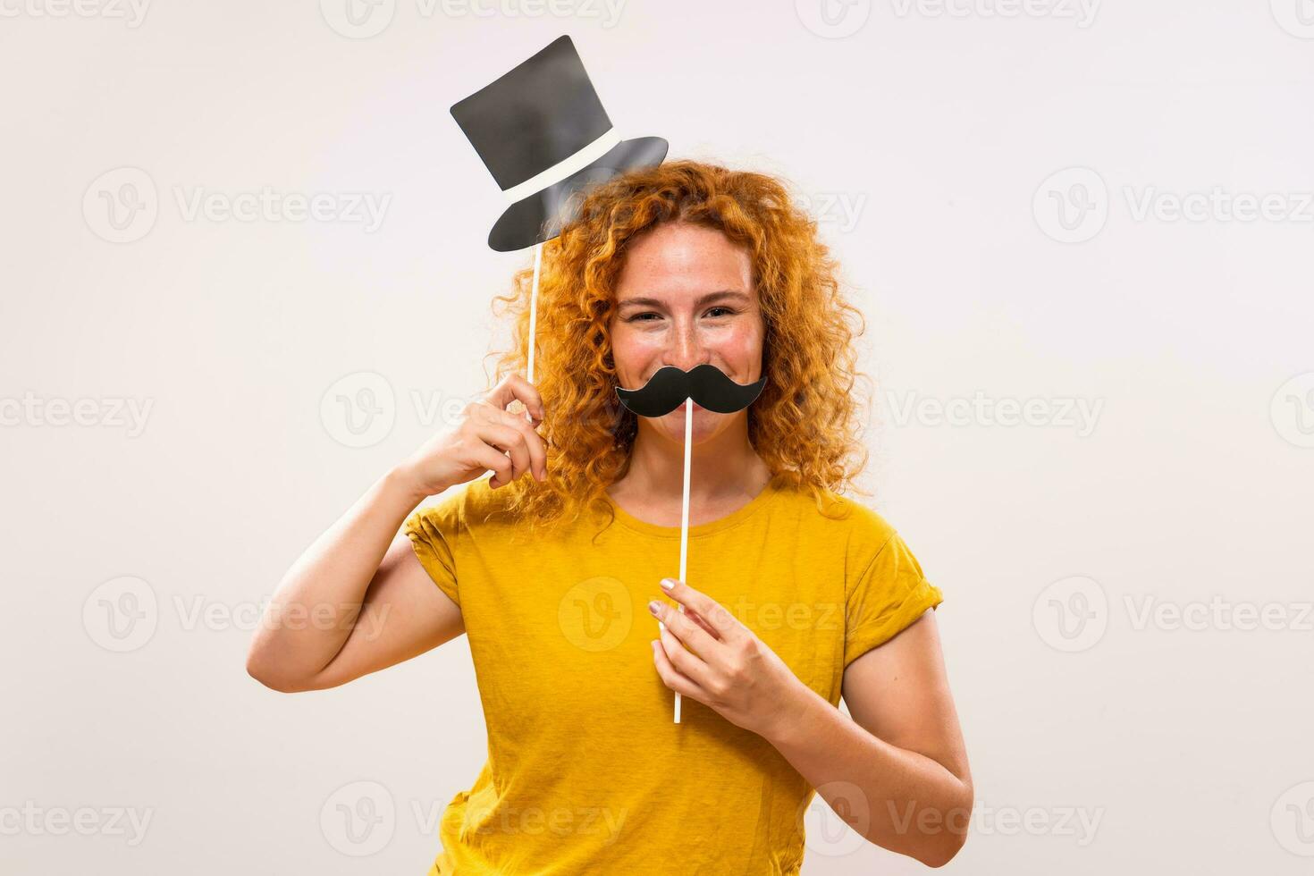 Happy ginger woman is having fun with party props photo