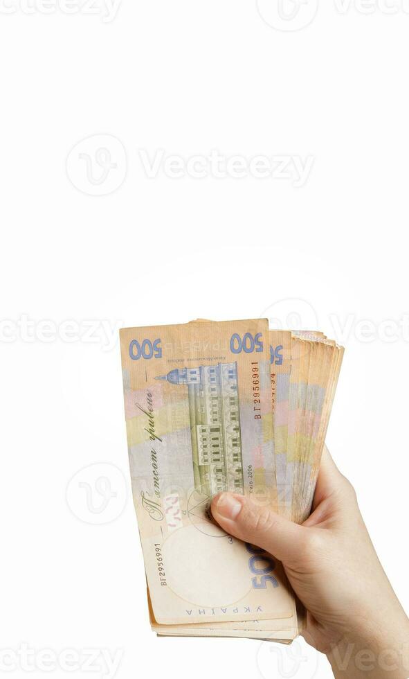hand holds a bundle of five hundred hryvnia banknotes on a white background. isolate. selective focus. free space for text. High quality photo