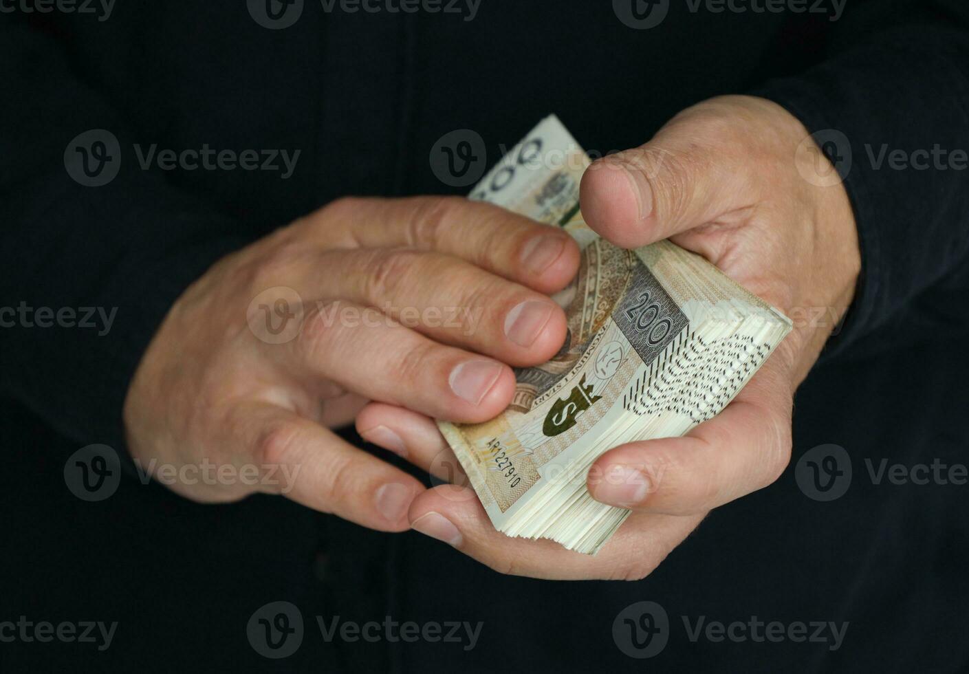 stack of large banknotes in the hands of a man. selective focus photo