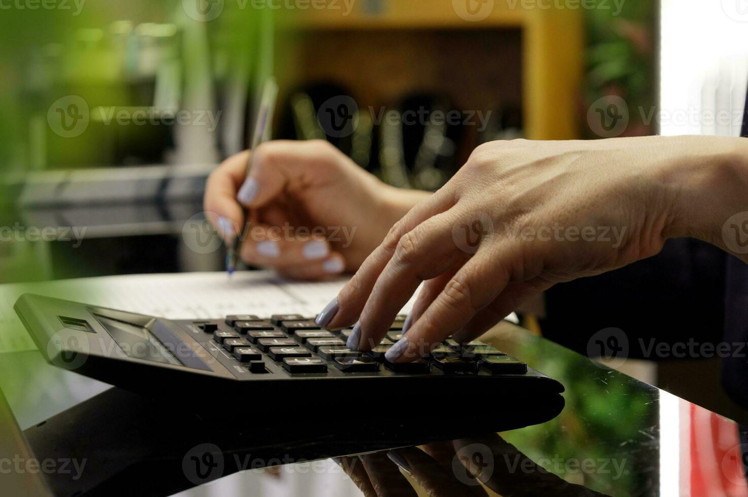 manos de mujer quien contar el estimar en el calculadora y grabar el datos. selectivo foco.alto calidad foto