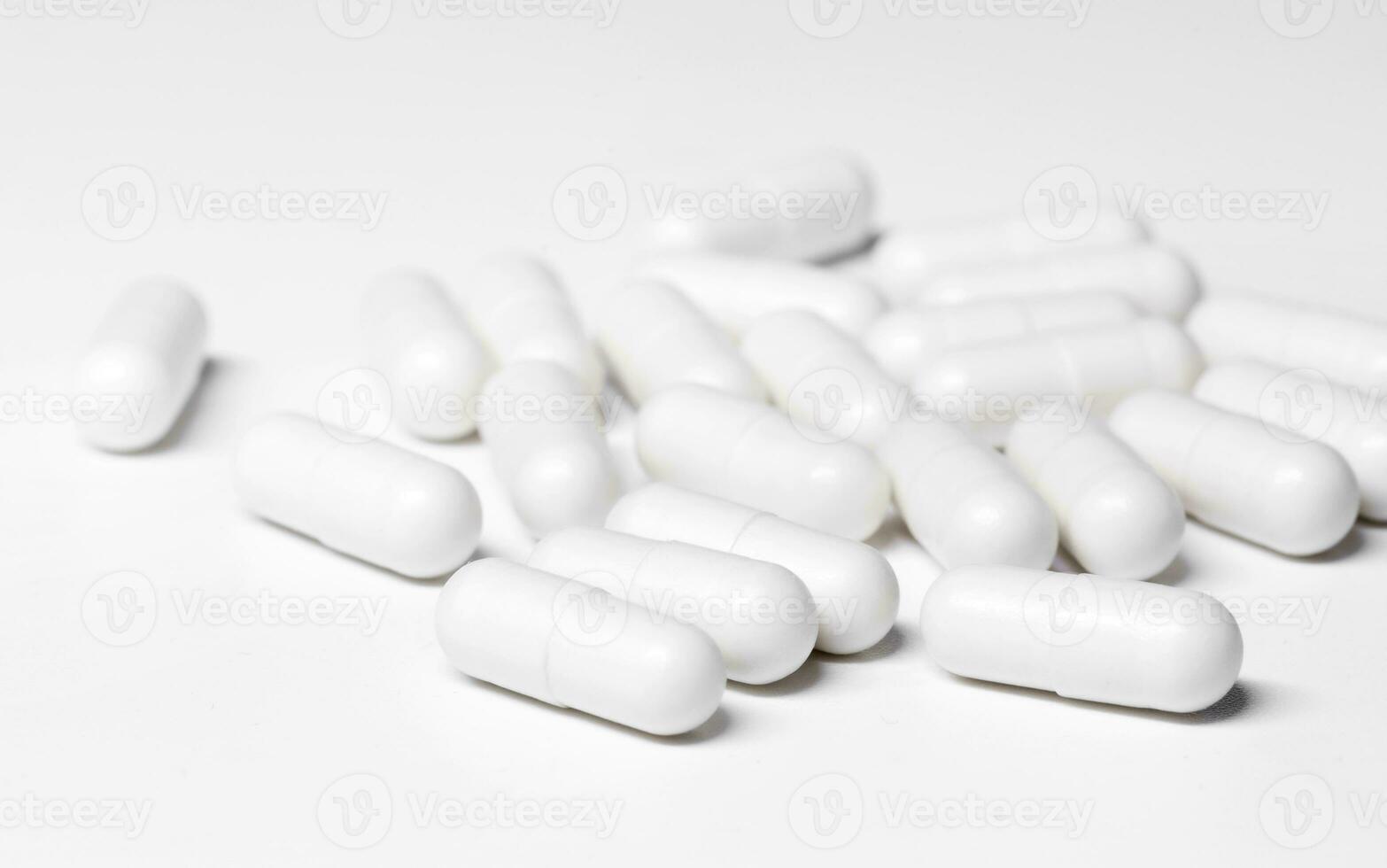 a lot of white pills are lying on the white table. Health and Medicine Concept. High quality photo
