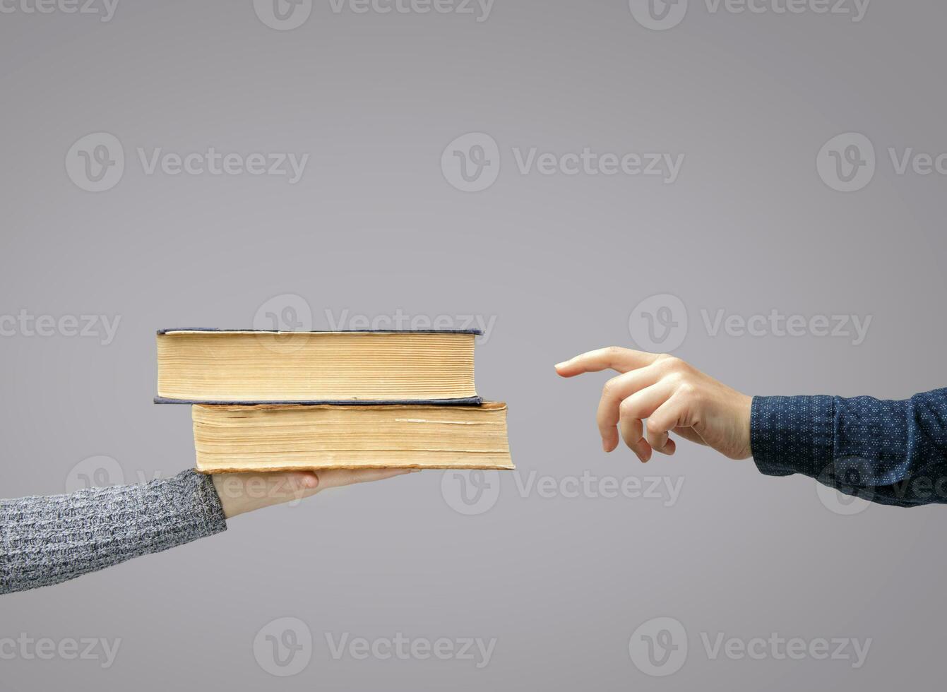 hand reaches for the books that lie on the palm of the invisible man. High quality photo