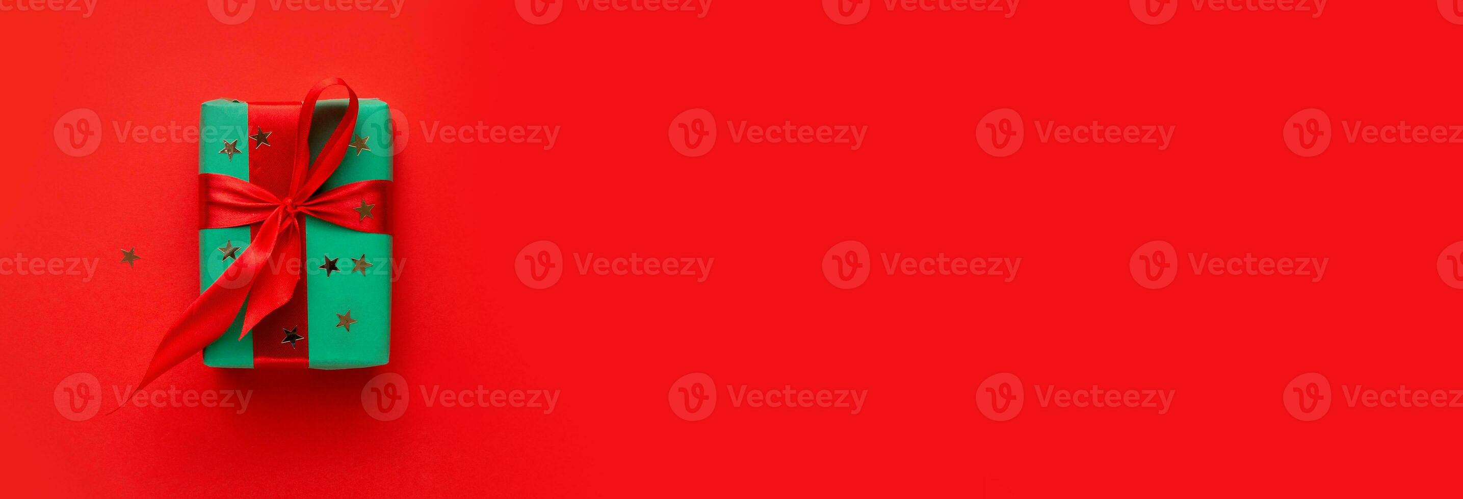 Christmas composition . Christmas gift on the red background . Green box with red ribbon .Flat lay . Top view . Mockup . Copy space .Free space . photo