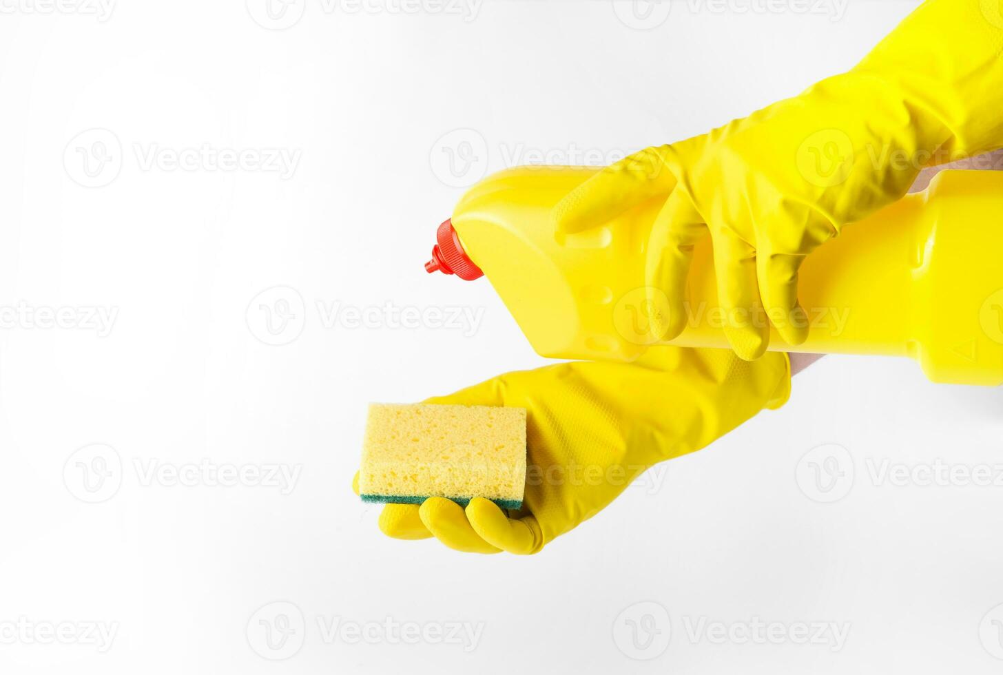 Hands in rubber gloves holding a plastic bottle with detergent and a sponge, on a white background. Cleaning kit. free space for text. High quality photo