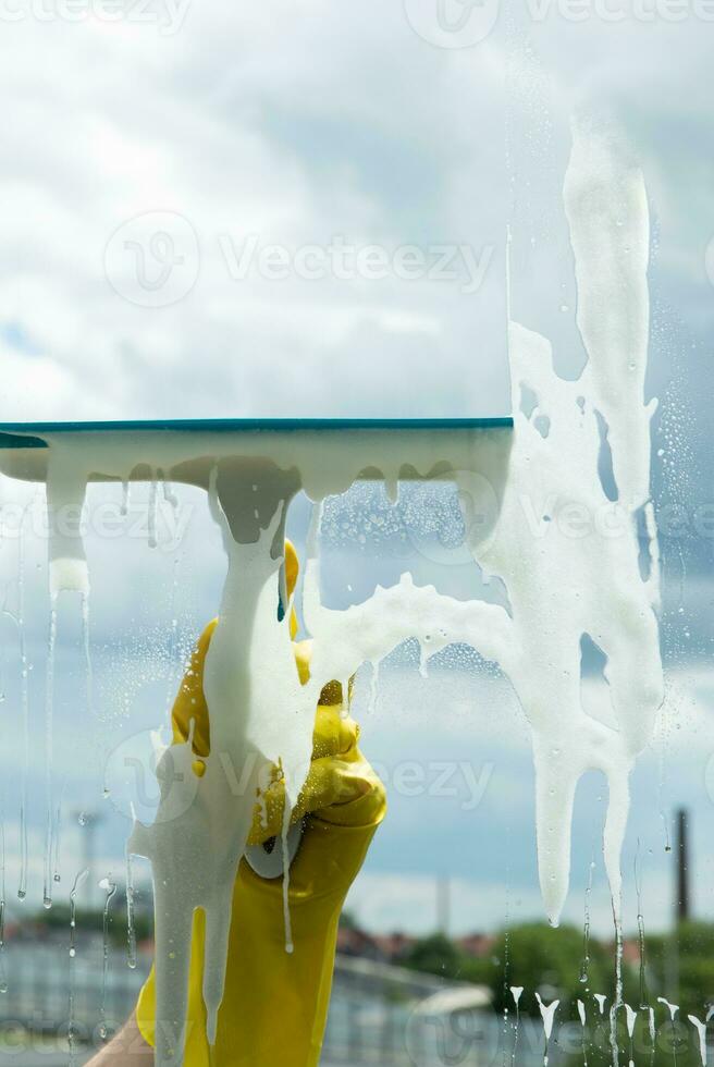 Window cleaning with a scraper and window cleaner. Cleaning in a house or apartment. Removing dirt from windows and windows. High quality photo