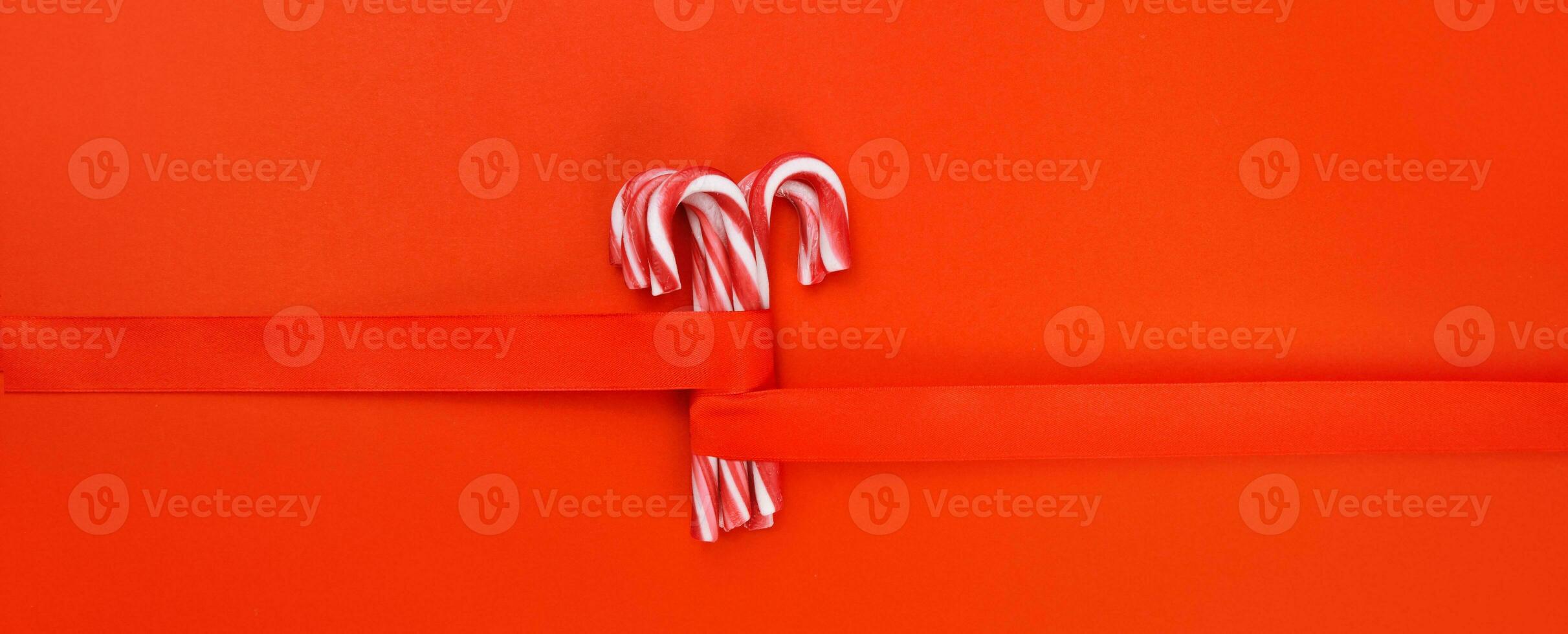 caramel canes with red ribbon on red background. High quality photo