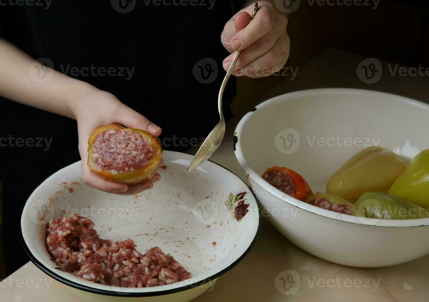 niña sostiene campana pimienta relleno con carne y arroz . el proceso de haciendo cena . suave selectivo atención . paso por paso de hecho en casa estofado relleno pimienta . foto