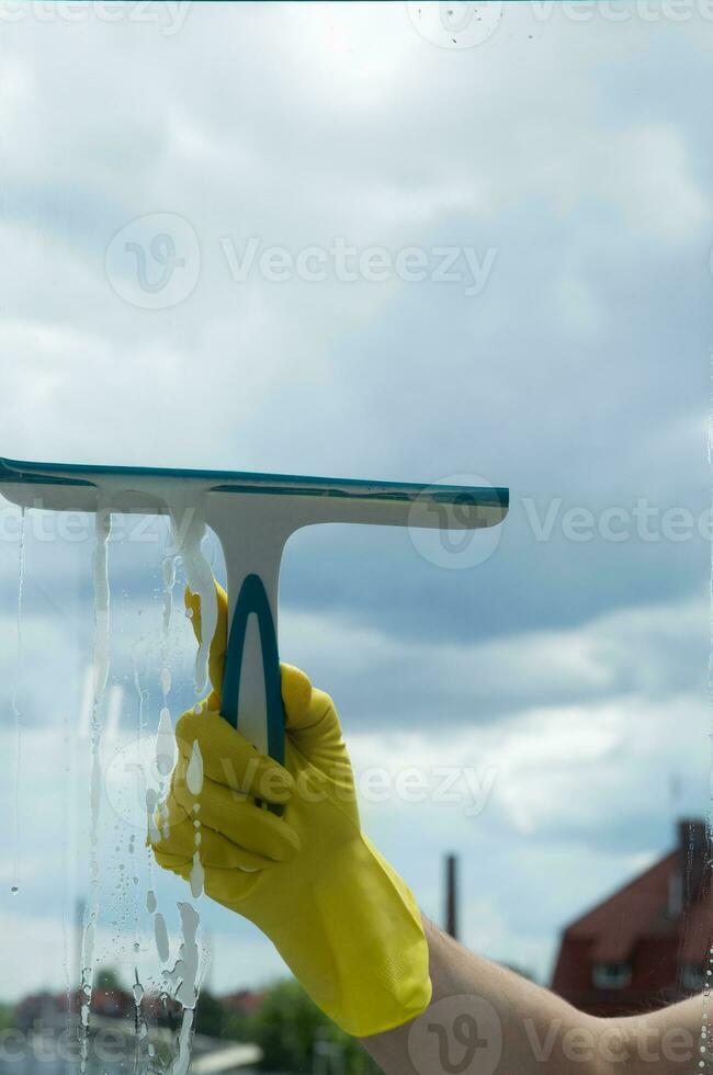 Window cleaning with a scraper and window cleaner. Cleaning in a house or apartment. Removing dirt from windows and windows. High quality photo