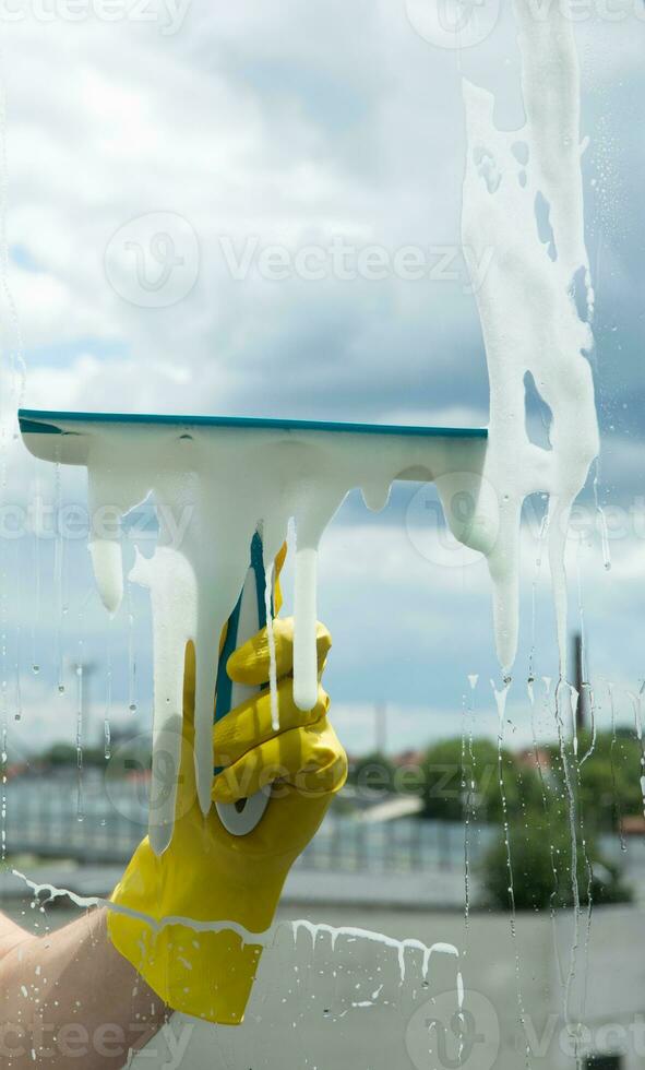 ventana limpieza con un raspador y ventana limpiador. limpieza en un casa o departamento. quitando suciedad desde ventanas y ventanas alto calidad foto