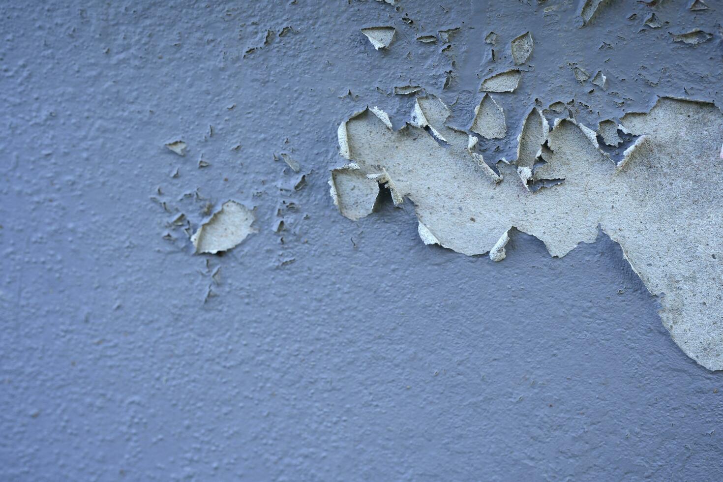 White peeling paint wall surface with moldy.Weathered concrete pattern wall.Old white color painted peeling off moment to do can see raw concrete texture wall.Swelling concrete wall texture. photo