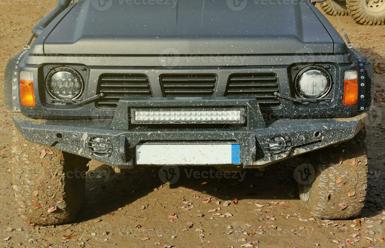 Automobile in a countryside landscape with a mud road. Off-road 4x4 suv automobile with ditry body after drive in muddy road photo