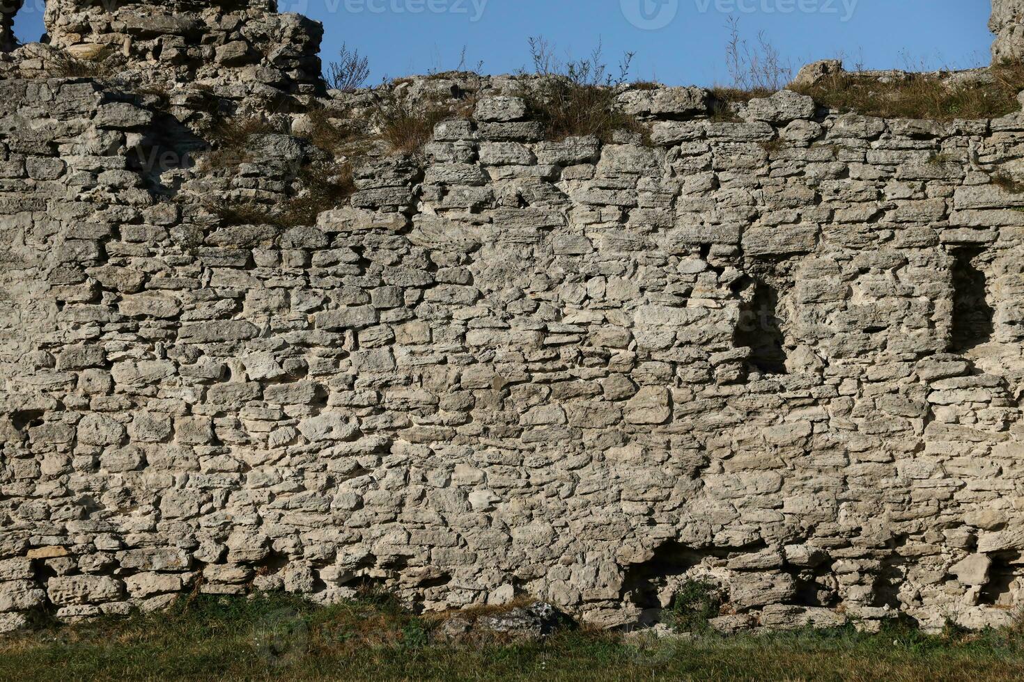 Very old brick stone wall of castle or fortress of 18th century. Full frame wall with obsolete dirty and cracked bricks photo