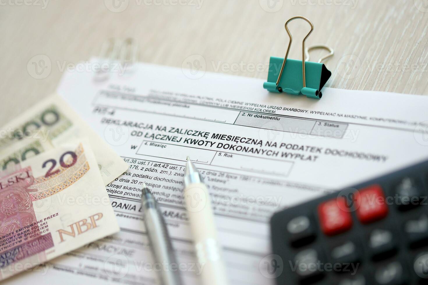 Declaration of a monthly advance payment for income tax on the total amount of payments, PIT-4 form on accountant table with pen and polish zloty money bills photo