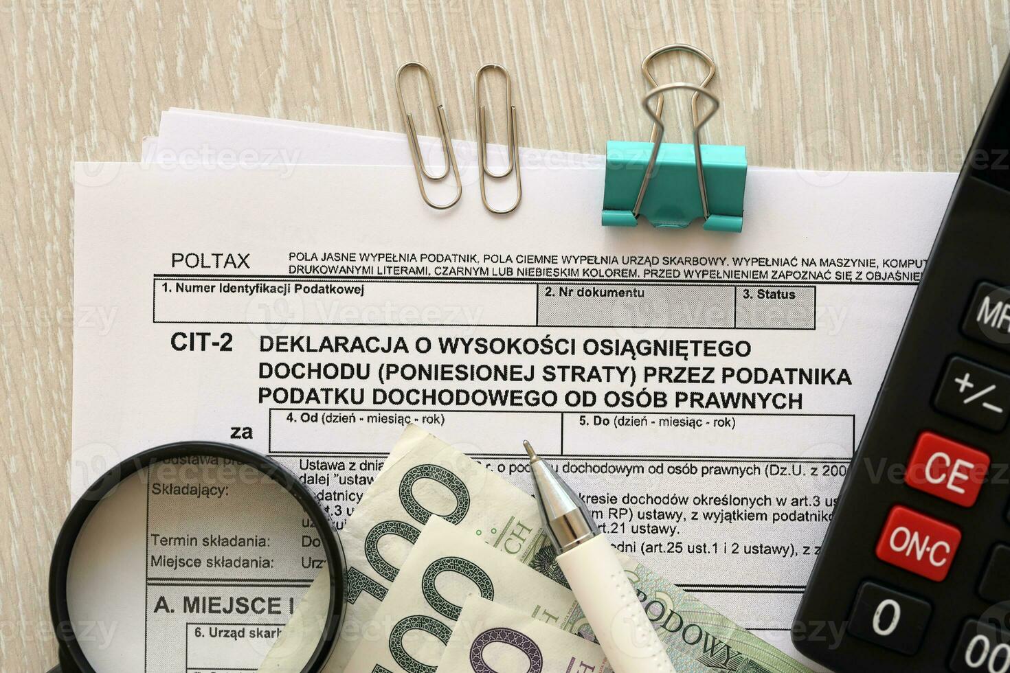Declaration of the amount of earned income or incurred loss by corporate income tax payer, CIT-2 tax forms on accountant table with pen and polish zloty money bills photo
