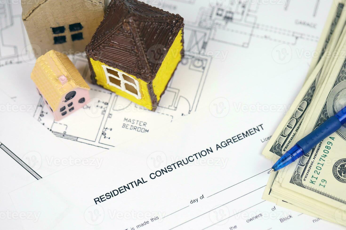 Residential construction agreement ready to sign with small toy houses and pen. Construction contract photo