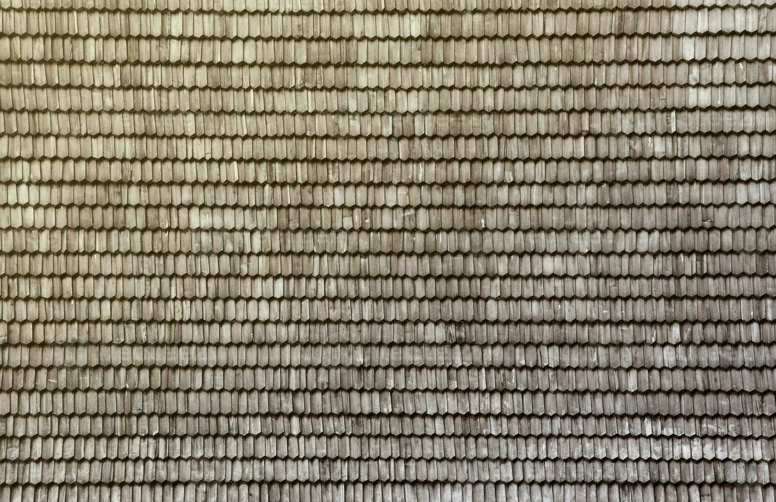 Gray wooden roof tiles background texture. A close up of old gray roof covered with wooden tiles photo