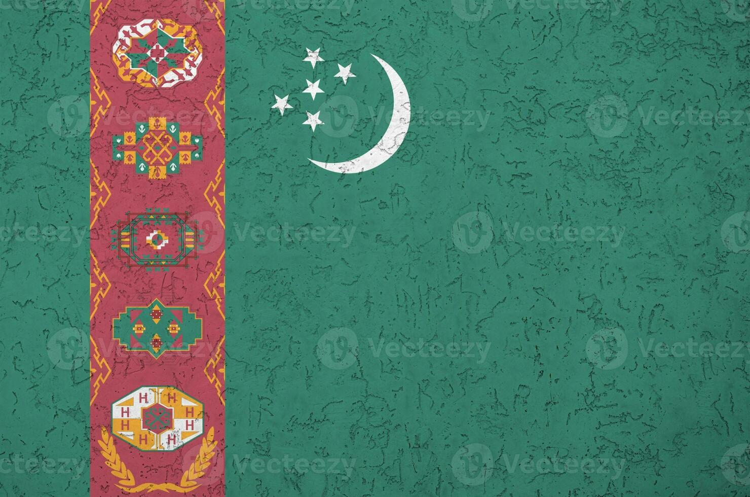 Turkmenistan flag depicted in bright paint colors on old relief plastering wall. Textured banner on rough background photo