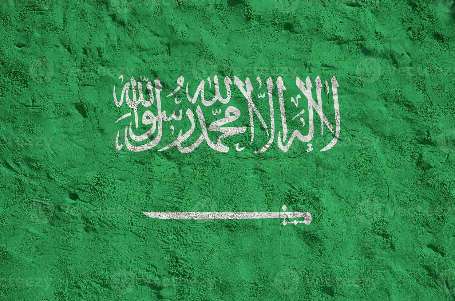 Saudi Arabia flag depicted in bright paint colors on old relief plastering wall. Textured banner on rough background photo