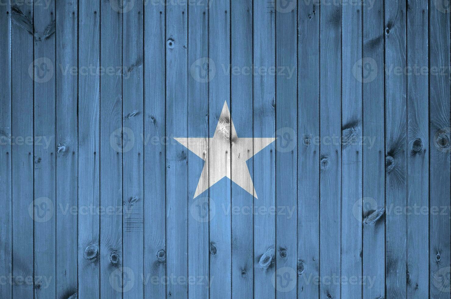 Somalia flag depicted in bright paint colors on old wooden wall. Textured banner on rough background photo