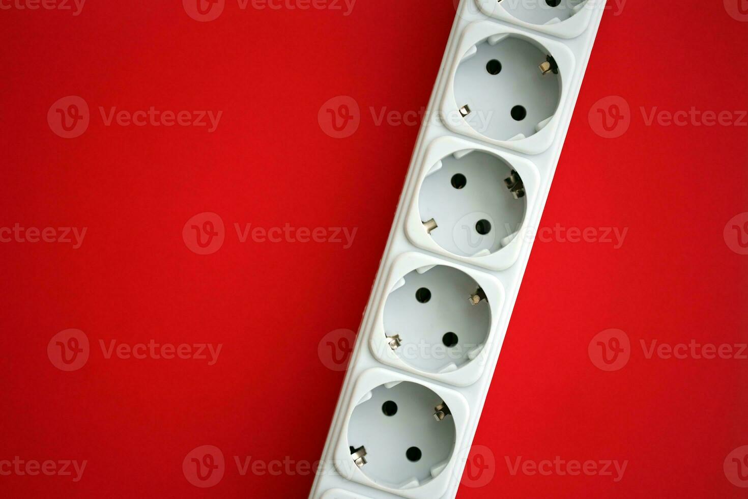White electrical multi plug extender with european socket on bright red background photo