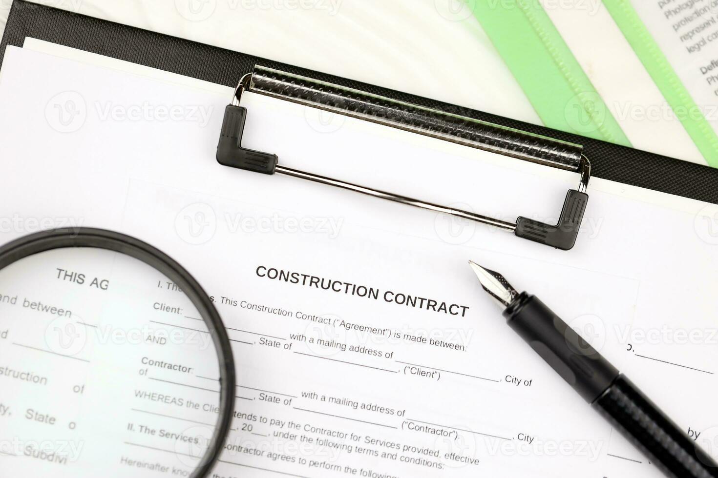 Construction contract form on A4 tablet lies on office table with pen and magnifying glass photo