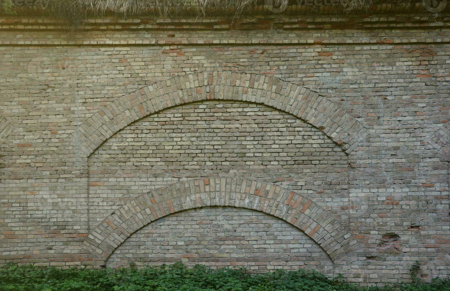 Very old brick stone wall of castle or fortress of 18th century. Full frame wall with obsolete dirty and cracked bricks photo