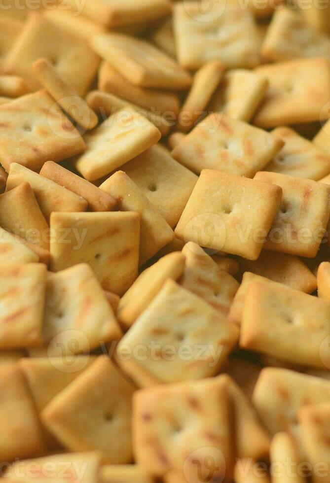 Background texture of small edible squares baked from dough and sprinkled with salt. A lot of salt cracker photo