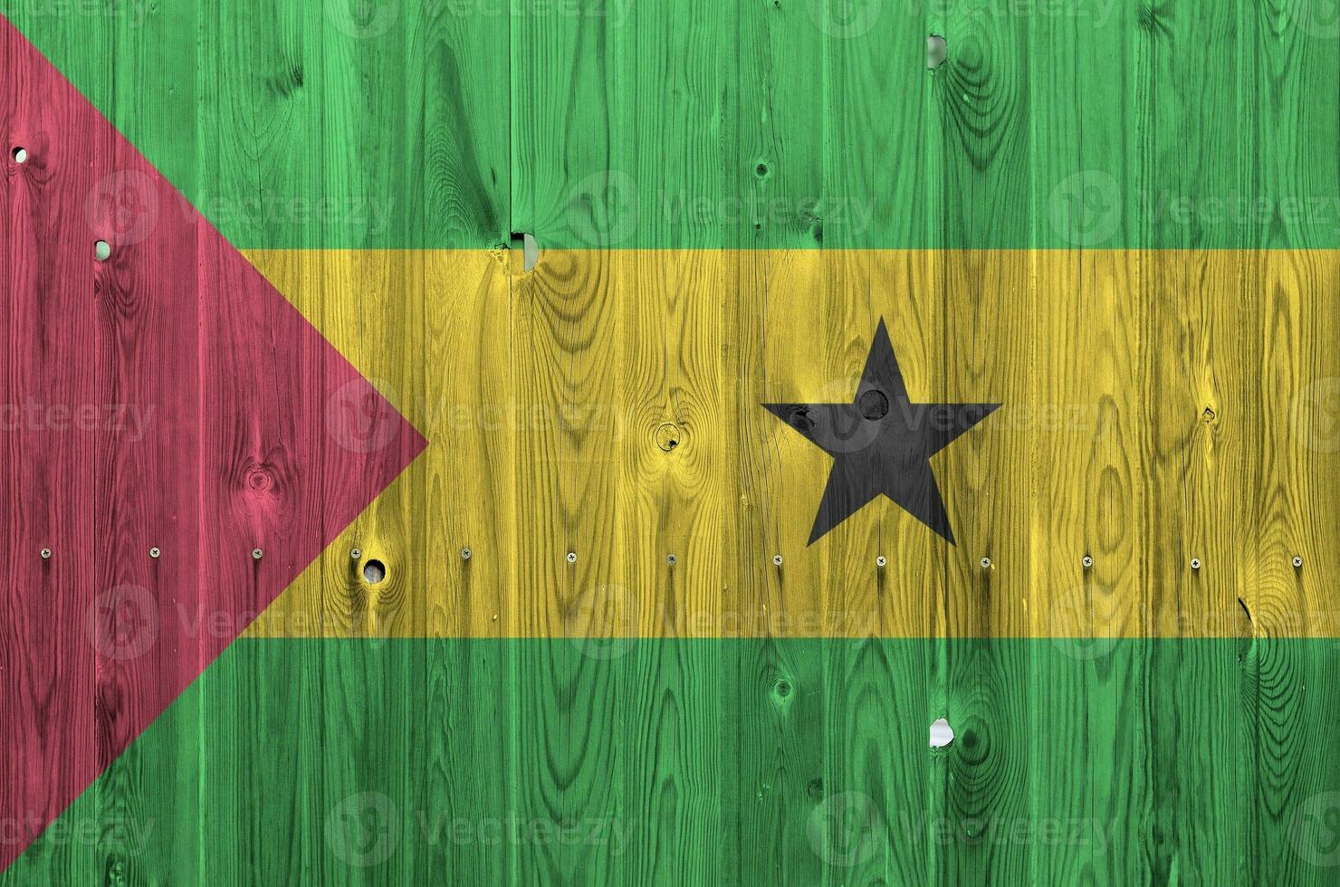 Sao Tome and Principe flag depicted in bright paint colors on old wooden wall. Textured banner on rough background photo