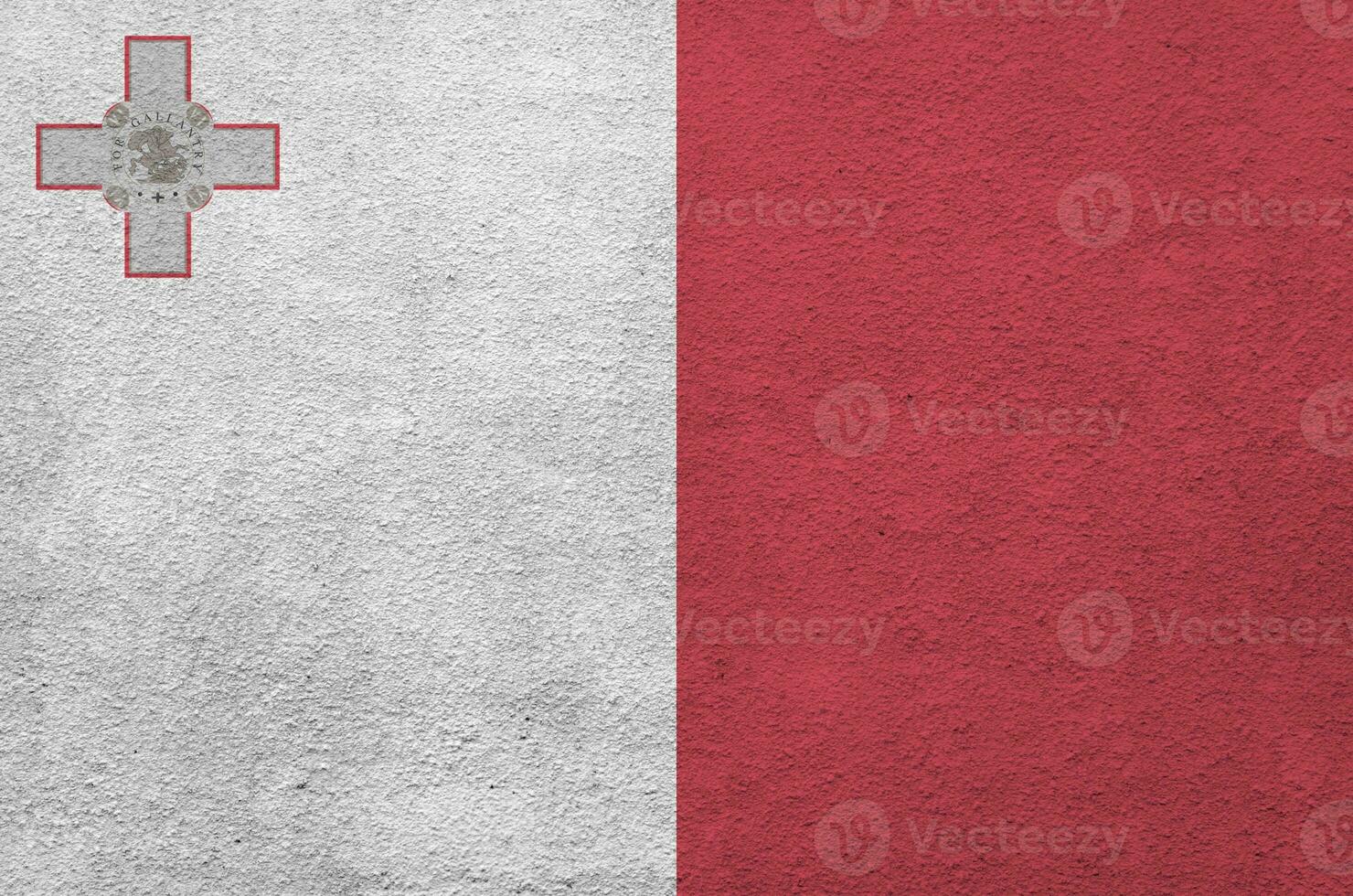 Malta flag depicted in bright paint colors on old relief plastering wall. Textured banner on rough background photo