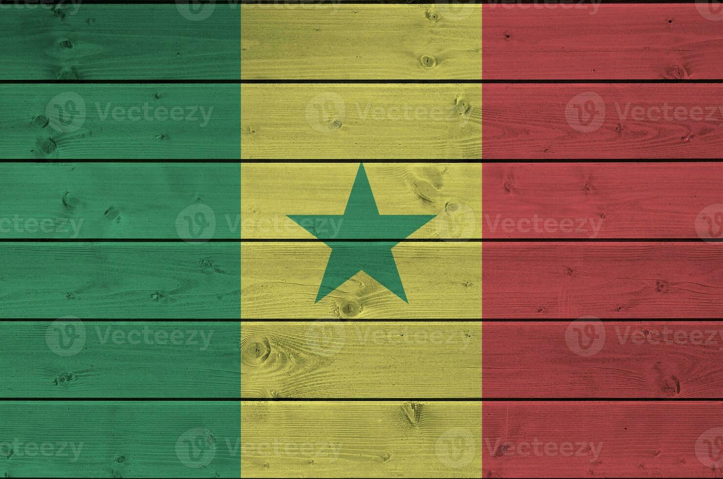 Senegal flag depicted in bright paint colors on old wooden wall. Textured banner on rough background photo