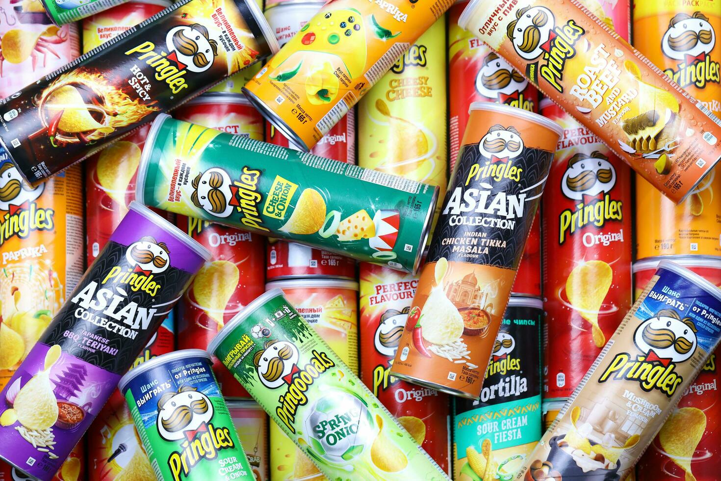 KHARKOV, UKRAINE - MARCH 30, 2021 Many Pringles cylinder chips boxes with varios colors and flavours. American brand of stackable potato-based crisps photo