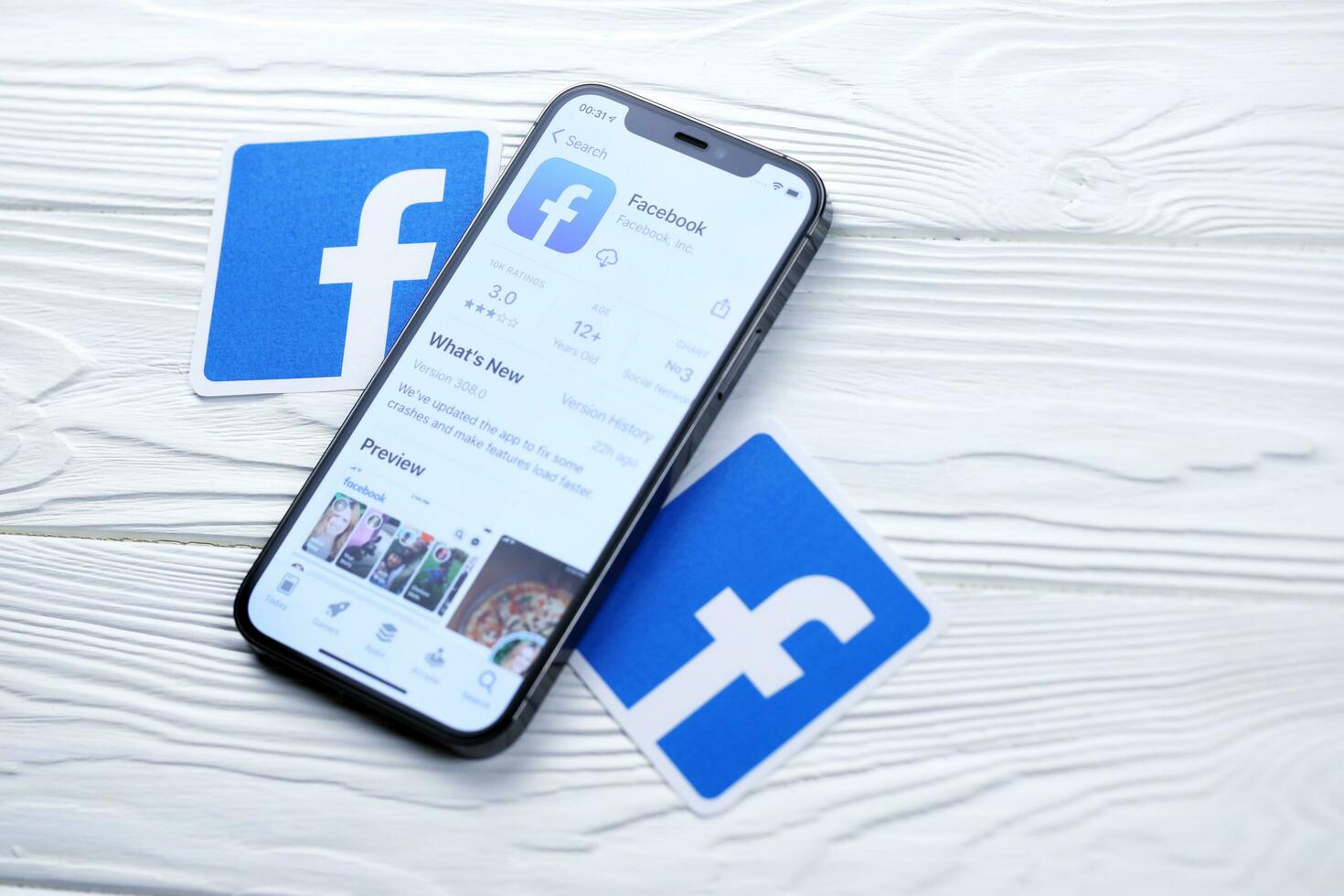 KHARKOV, UKRAINE - MARCH 5, 2021 Facebook icon and application from App store on iPhone 12 pro display screen on white table photo