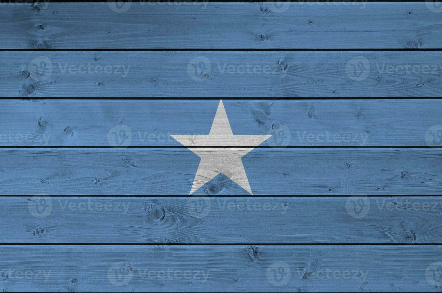 Somalia flag depicted in bright paint colors on old wooden wall. Textured banner on rough background photo