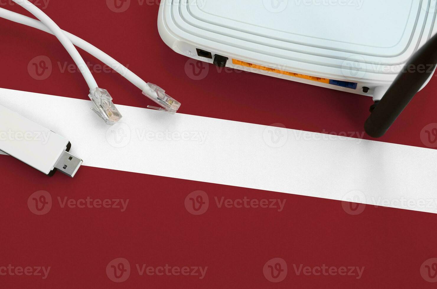 Latvia flag depicted on table with internet rj45 cable, wireless usb wifi adapter and router. Internet connection concept photo