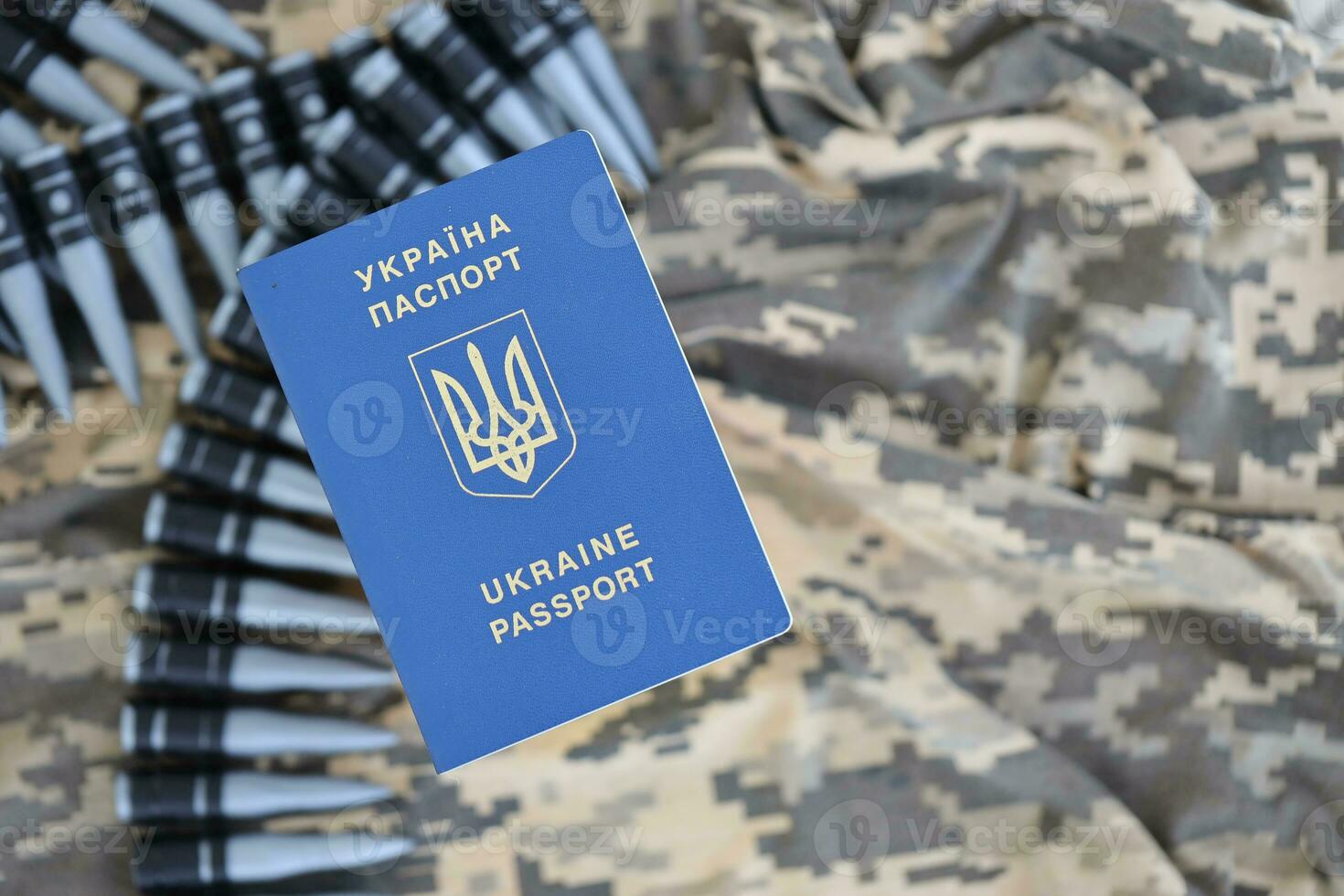 Ukrainian foreign passport on fabric with texture of military pixeled camouflage. Cloth with camo pattern in grey, brown and green pixel shapes and Ukrainian ID photo